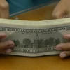 Đồng tiền mệnh giá 100 USD. (Ảnh: AFP/ TTXVN)