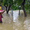 Một người đàn ông lội qua nước lũ ở Sylhet, Bangladesh. (Nguồn: AFP)