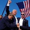 Ông Donald Trump được mật vụ Mỹ hộ tống khỏi sân khấu của sự kiện vận động tranh cử tại bang Pennsylvania sau khi xảy ra vụ nổ súng, ngày 13/7/2024. (Ảnh: AP/TTXVN)