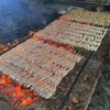 Một mẻ cá được nướng trên bếp than củi. (Ảnh: Hữu Quyết/TTXVN)