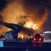 Lính cứu hỏa nỗ lực dập lửa máy bay chở khách bị cháy sau va chạm với máy bay của Lực lượng bảo vệ bờ biển Nhật Bản, tại Sân bay Haneda ở Tokyo, tối 2/1/2024. (Ảnh: Kyodo/TTXVN)