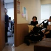 Jung Seung-yeon (phải), 38 tuổi, đưa con trai đi khám tại một phòng khám nhi ở Seoul. (Ảnh: Reuters)