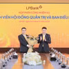 Ông Nguyễn Đức Thụy - Chủ tịch Hội đồng quản trị LPBank (phải) tặng hoa chúc mừng cho ông Hồ Nam Tiến - Phó Chủ tịch thường trực Hội đồng quản trị (trái). (Ảnh: Vietnam+)