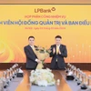 Ông Nguyễn Đức Thụy - Chủ tịch Hội đồng quản trị LPBank (phải) tặng hoa chúc mừng cho ông Hồ Nam Tiến - Phó Chủ tịch thường trực Hội đồng quản trị (trái). (Ảnh: Vietnam+)