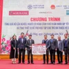 Ông Phạm Đức Ấn - Chủ tịch Hội đồng thành viên Agribank trao tặng quà của Agribank hỗ trợ hộ cận nghèo, đối tượng chính sách quận Hà Đông (Hà Nội) nhân dịp Tết Nguyên đán Giáp Thìn. (Ảnh: Vietnam+)