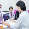 Khách hàng cập nhập khuôn mặt tại phòng giao dịch. (Ảnh: Vietnam+)