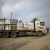 Xe tải chở hàng viện trợ chuẩn bị qua cửa khẩu Kerem Shalom. (Ảnh: THX/TTXVN)
