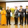 Ông Nguyễn Xuân Thắng, Uỷ viên Bộ Chính trị, Giám đốc Học viện Chính trị Quốc gia Hồ Chí Minh, Chủ tịch Hội đồng Lý luận Trung ương cùng Đoàn đại biểu Quốc hội tỉnh Quảng Ninh tặng hoa chúc mừng ông Đặng Xuân Phương. (Ảnh: Văn Đức/TTXVN)