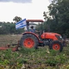 Một nhân viên tình nguyện lái máy cày tại một trang trại miền Trung Israel. (Ảnh: Vũ Hội/TTXVN)