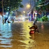 Đến gần 20 giờ, đường Bình Chiểu, thành phố Thủ Đức vẫn lênh láng nước. (Ảnh: Hồng Giang/TTXVN)