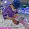 Y tá chăm sóc một đứa trẻ sơ sinh ở bệnh viện nhi tại tỉnh An Huy, Trung Quốc ngày 17/1/2024. (Ảnh: AP)