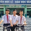 Em Lê Nhật Hảo (bên trái) và Chiêu Bình Sâm (bên phải), chụp ảnh với thầy Hiệu trưởng trường Trung học Cơ sở An Lạc, quận Bình Thạnh, Thành phố Hồ Chí Minh. (Nguồn: Yonhap News)