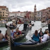 Khách du lịch đi thuyền gondola tại Venice, Italy. (Ảnh: AFP/TTXVN)