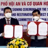 Ông Nguyễn Văn Sơn, Chủ tịch Ủy ban Nhân dân thành phố Hội An, trao đổi văn bản ký kết hỗ trợ với ông Shimizu Akira, Trưởng Đại diện Văn phòng JICA Việt Nam. (Ảnh: Trịnh Bang Nhiệm/TTXVN)