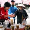 Anh chị em tổ cơm từ thiện bán các suất cơm từ thiện tới người có hoàn cảnh khó khăn. (Ảnh: Hoàng Ngọc/TTXVN)