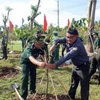 Đoàn đại biểu sỹ quan biên phòng Việt Nam - Campuchia trồng cây hữu nghị tại Đồn Biên phòng Lình Huỳnh, huyện Hòn Đất, tỉnh Kiên Giang. (Ảnh: Lê Sen/TTXVN)