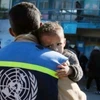 Thành viên Cơ quan cứu trợ và việc làm của LHQ dành cho người tị nạn Palestine (UNRWA) bên một em nhỏ Palestine ở Dải Gaza. (Ảnh: UN News/TTXVN)