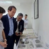 Bà Trần Việt Hoa, Giám đốc Trung tâm Lưu trữ Quốc gia III (trái) cùng các đại biểu xem xét khối tư liệu mới được giải mật. (Ảnh: Minh Thu/Vietnam+)