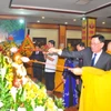 Các vị đại biểu tiến hành nghi thức tắm Phật. (Ảnh: PV/Vietnam+)
