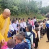 Thượng tọa Thích Minh Quang, Trưởng ban Điều phối và hợp tác Giáo hội Phật giáo Việt Nam tại Lào phát quần áo cho những trẻ em bị ảnh hưởng do lũ lụt ở Lào. (Ảnh: TTXVN phát)