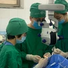 Các bác sỹ Bệnh viện Mắt Trung ương thực hiện ca ghép giác mạc cho bệnh nhân. (Ảnh: PV/Vietnam+)