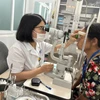 Bác sỹ Bệnh viện Mắt Trung ương khám cho bệnh nhân. (Ảnh: PV/Vietnam+)