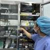 Nhân viên y tế kiểm tra tủ thuốc. (Ảnh: T.G/Vietnam+)