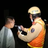 Cảnh sát giao thông kiểm tra nồng độ cồn đối với tài xế xe ôtô. (Ảnh: Hữu Chí/TTXVN)