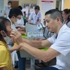 Bác sỹ khám cho trẻ mắc dị tật khe hở môi, vòm miệng. (Ảnh: PV/Vietnam+)