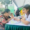 Nhân viên y tế tư vấn dinh dưỡng cho người dân đến tham gia Chương trình. (Ảnh: PV/Vietnam+)