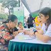 Nhân viên y tế tư vấn dinh dưỡng cho người dân đến tham gia Chương trình. (Ảnh: PV/Vietnam+)