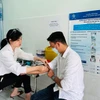 Nhân viên y tế Trung tâm Kiểm soát bệnh tật tỉnh Kiên Giang lấy mẫu xét nghiệm theo dõi điều trị HIV cho một bệnh nhân. (Ảnh: T.G/Vietnam+)