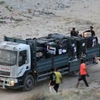Xe tải chở hàng viện trợ di chuyển vào miền Trung Dải Gaza ngày 18/5/2024. (Ảnh: AFP/TTXVN)