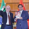Ông Pedro de Oliveira, Tổng Thư ký Hội Hữu nghị Brazil-Việt Nam tặng Thủ tướng Phạm Minh Chính cuốn sách Hồ Chí Minh cuộc đời và sự nghiệp vị lãnh tụ giải phóng dân tộc Việt Nam. (Ảnh: Dương Giang/TTXVN)