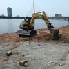 Dọn đống đất đá, xà bần ven bờ Sông Hàn. (Ảnh: Quốc Dũng/TTXVN)