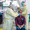 Nhân viên y tế lấy mẫu xét nghiệm COVID-19 cho người dân tại Singapore hồi năm ngoái. (Ảnh: AFP/TTXVN)