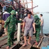 Lực lượng Bộ đội Biên phòng tỉnh Quảng Bình đưa các ngư dân bị nạn trên biển vào bờ. (Ảnh: TTXVN phát)