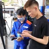 Nhân viên Petrolimex in hóa đơn mua xăng cho khách hàng. (Ảnh: Đức Duy/Vietnam+)