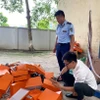 Lực lượng chức năng kiểm tra hàng hóa có dấu hiệu giả mạo nhãn hiệu HERMÈS. (Ảnh: PV/Vietnam+)