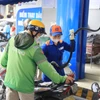 Nhân viên Petrolimex bán xăng cho khách hàng. (Ảnh: Đức Duy/Vietnam+)