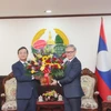 Đại sứ Nguyễn Minh Tâm tặng hoa chúc mừng 49 năm Quốc khánh Lào cho Bộ trưởng Bộ Ngoại giao Lào Thongsavanh Phomvihane. (Ảnh: Xuân Tú/TTXVN)