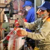 Công nhân Công ty Cổ phần Supe Phốt phát và Hóa chất Lâm Thao đóng gói bao bì sản phẩm phân bón mới. (Ảnh: Trung Kiên/TTXVN)