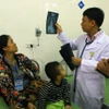 Bác sỹ Bệnh viện Sản nhi Nghệ An xem phim chụp XQ của bệnh nhi. (Ảnh: Tá Chuyên/TTXVN) 