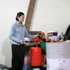 Đối tượng Quách Thị Thu Hồng thực hiện lại hành vi san chiết nhớt giả. (Ảnh: Xuân Triệu/TTXVN)