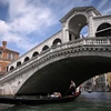 Khách du lịch đi thuyền gondola tại Venice, Italy. (Ảnh: AFP/TTXVN)