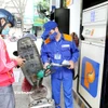 Nhân viên Petrolimex bán xăng cho khách hàng. (Ảnh: Đức Duy/Vietnam+)