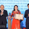 Phó Thủ tướng Thường trực Trương Hòa Bình (bên trái) và Bí thư Trung ương Đoàn, Chủ tịch Trung ương Hội Sinh viên Việt Nam Bùi Quang Huy trao Bằng khen và biểu trưng, tuyên dương 'Nhà giáo trẻ tiêu biểu' cấp Trung ương lần thứ II.(Ảnh: Văn Điệp/TTXVN)