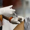 Người dân tiêm vaccine ngừa COVID-19. (Ảnh: AFP/TTXVN)