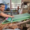 Nghệ nhân lớn tuổi người Chăm dệt vải thổ cẩm truyền thống. (Ảnh: Nguyễn Thành/TTXVN)