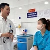 Bác sỹ thăm khám bệnh nhân sau ca phẫu thuật. (Ảnh: TTXVN phát)